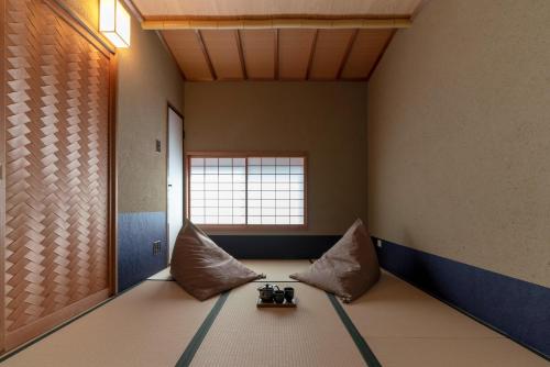 um quarto com um sofá com almofadas e uma janela em Hinaya Higashiyama Machiya House em Kanazawa