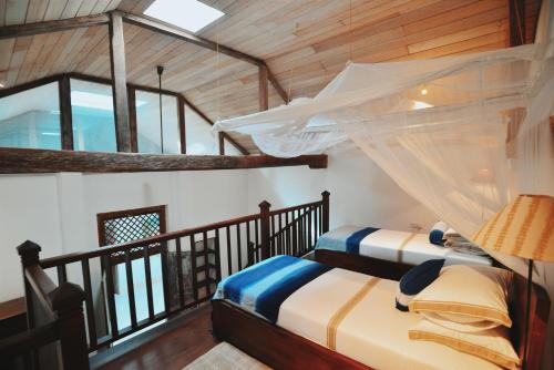 two beds in a room with a balcony at Villa 32 Middle Street in Galle