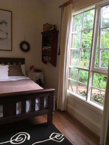 a bedroom with a bed and a large window at Belgrave Hideaway in Belgrave