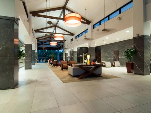 a lobby with couches and tables in a building at Temple Resort & Spa Port Douglas in Port Douglas