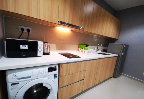 a kitchen with a washing machine and a microwave at Host Assist Homestay by HA i-City in Shah Alam