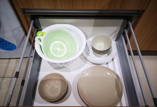 a glass cabinet with dishes and a fan on it at Host Assist Homestay by HA i-City in Shah Alam