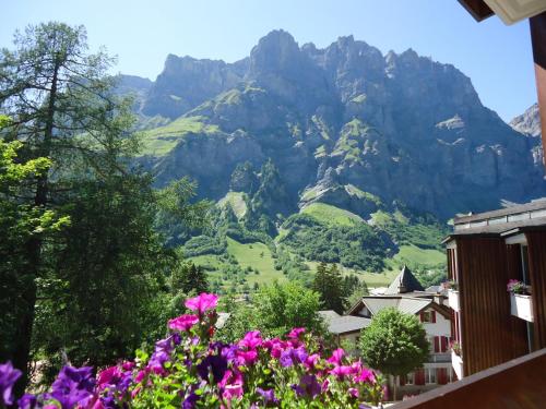 a view of a mountain with flowers in the foreground at Hotel Quellenhof Leukerbad in Leukerbad