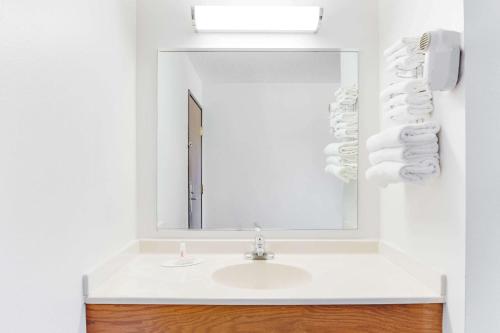 La salle de bains est pourvue d'un lavabo et d'un miroir. dans l'établissement Super 8 by Wyndham Oelwein, à Oelwein