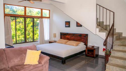 a bedroom with a bed and a couch and stairs at CW2 Casa Wasabi 2bed+1bath in Tamarindo