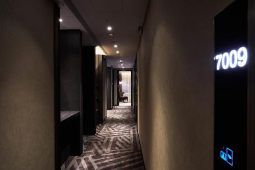 a hallway of a hotel with neon signs on the wall at The Tango Hotel Taipei Jiantan in Taipei