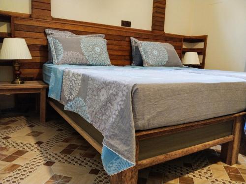 a bedroom with a bed with a wooden headboard at Akiri Surf Retreat in Thulusdhoo
