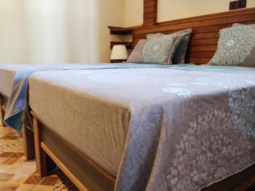 a bedroom with two beds with a blue blanket at Akiri Surf Retreat in Thulusdhoo
