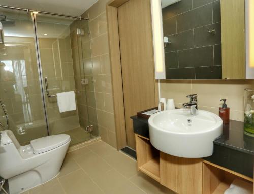 a bathroom with a sink and a toilet and a shower at Citadines Central Binh Duong in Thuan An
