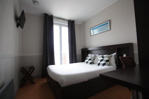 Hotel De La Rade في بريست: غرفة نوم بسرير ونافذة