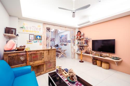 a living room with a tv and a blue couch at 安平72號民宿 in Tainan