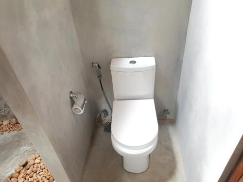 a bathroom with a white toilet in a stall at Guruwaththa Eco Lodge in Hikkaduwa
