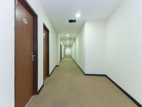 an empty corridor of an office building with doors at Central Hotel in Bahau