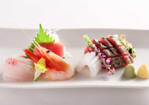 a white plate with sushi and other foods on it at Aura Tachibana in Hakone