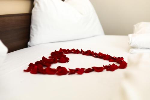 a heart of red roses on a bed at Primus Hotel & Apartments in Vienna