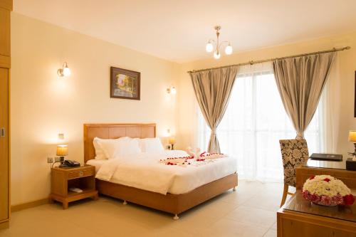 Un dormitorio con una cama y una ventana con flores. en Lotos Inn & Suites, Nairobi, en Nairobi