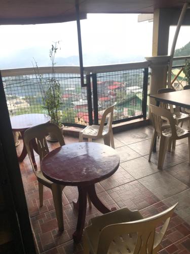 a table and chairs on a balcony with a view at ASHBURN'S TRANSIENT BAGUIO - 3rd to 5th floor BASIC SLEEP and GO Accommodation, WITH PARKING, NO ELEVATOR in Baguio
