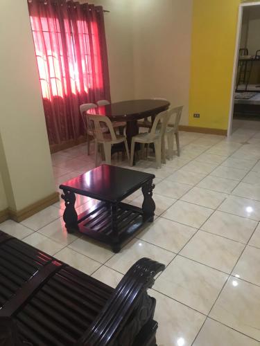 a living room with a black table and chairs at ASHBURN'S TRANSIENT BAGUIO - 3rd to 5th floor BASIC SLEEP and GO Accommodation, WITH PARKING, NO ELEVATOR in Baguio