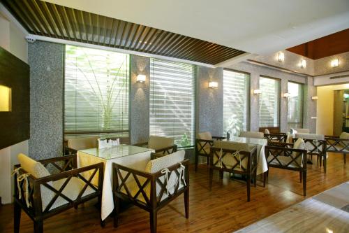 a dining room with tables and chairs and windows at Jing Hwa Motel in Tainan