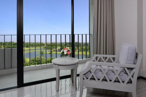 d'un balcon avec une table, une chaise et une fenêtre. dans l'établissement Tinidee Hotel Bangkok Golf Club - SHA Certified, à Pathum Thani