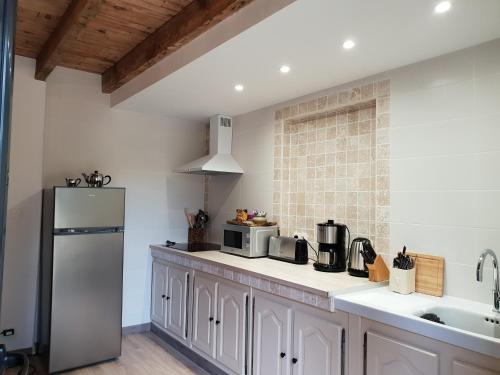 a kitchen with white cabinets and a refrigerator at Studio Fontaine d’amour in Sarlat-la-Canéda