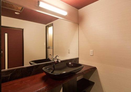 a bathroom with a black sink and a mirror at Aura Tachibana in Hakone