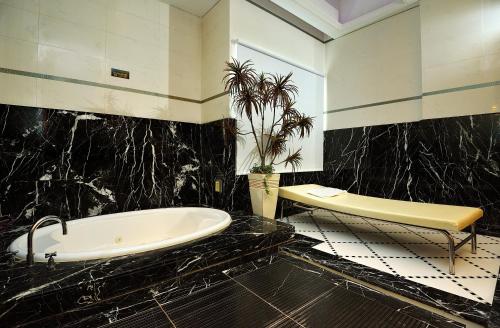 a bathroom with a tub and a potted plant at Jing Hwa Motel in Tainan