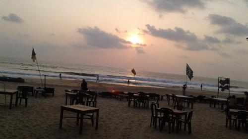 a group of tables and chairs on the beach at Guruwaththa Eco Lodge in Hikkaduwa