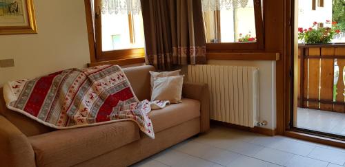 a couch with blankets on it in a living room at Baita al Pian in Bormio