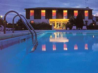 a swimming pool with a slide in front of a building at Logis Le Pont Bernet in Le Pian-Médoc