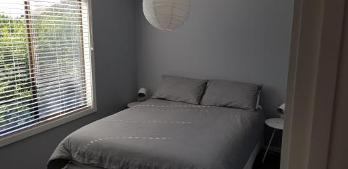 a small bedroom with a bed and a window at 4 Bounty in Corinella