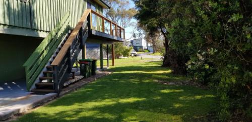 a grassy yard with a staircase next to a building at 4 Bounty in Corinella