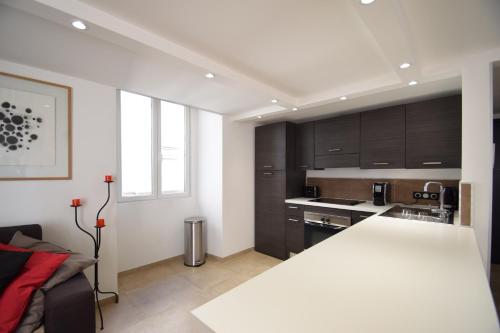 une cuisine avec des armoires noires et un comptoir blanc dans l'établissement Jade Duplex - No Better Location In Nice, à Nice