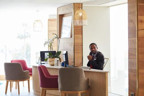 a man sitting at a desk in an office at President Hotel in Cape Town
