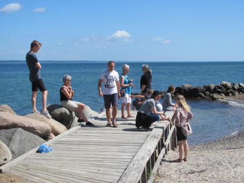 a group of people standing on a pier near the water at Dancamps Trelde Naes (Camp Site) in Fredericia