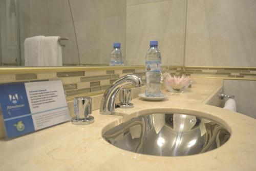 a bathroom sink with a bottle of water on it at Almuñecar Hotel in Tartagal