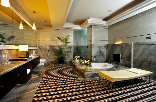 uma casa de banho com uma banheira, um lavatório e uma mesa em Jing Hwa Motel em Tainan