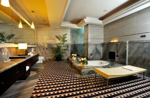 a bathroom with a tub and a sink and a table at Jing Hwa Motel in Tainan