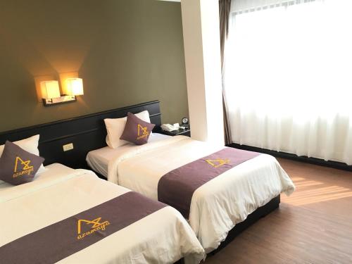金邊的住宿－Azumaya Hotel Phnom Penh，酒店客房设有两张床和窗户。