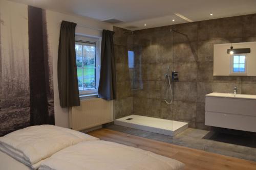 1 dormitorio con ducha, 1 cama y lavamanos en Vue d'en Haut, en Durbuy