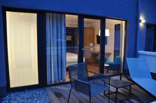 a room with two chairs and a table and a bedroom at Hotel The Royal Snail in Namur