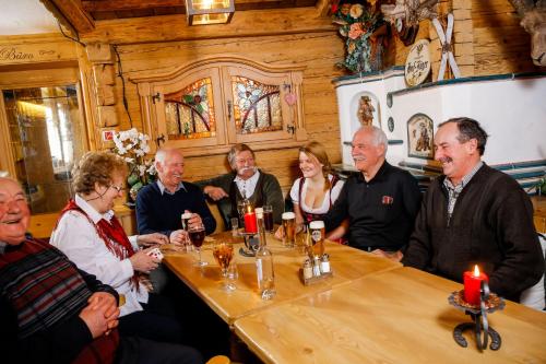 a group of people sitting around a table at Hotel Edelweiss in Hochfilzen