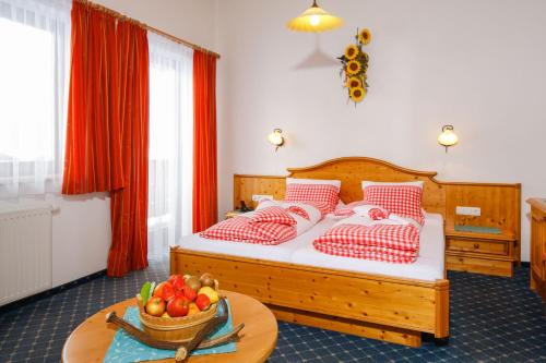 a bedroom with a bed and a table with a bowl of fruit at Hotel Edelweiss in Hochfilzen