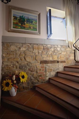 a room with stairs and a window and flowers at La Chiusuraccia in Barberino di Mugello