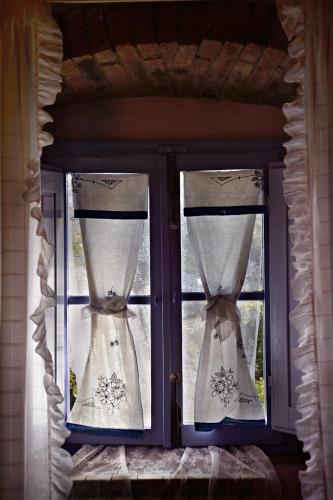 a window with two wedding dresses in it at La Chiusuraccia in Barberino di Mugello
