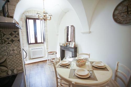 a dining room with a table and chairs and a clock at Dimora Maestà in Putignano