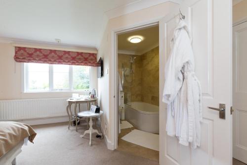 uma casa de banho com uma cama, uma banheira e um lavatório. em Whitethorn Bed and Breakfast em Congleton