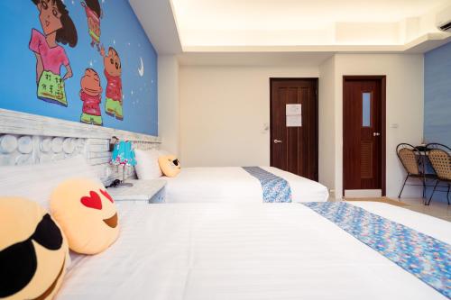 a bedroom with two beds and a wall with disney cartoons at 安平72號民宿 in Tainan