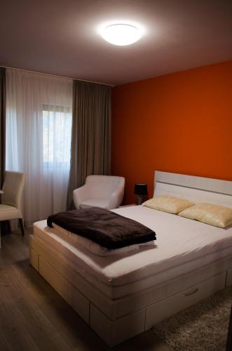 a bedroom with a large bed with an orange wall at Panoramic in Baia-Sprie