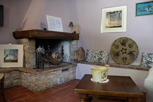 a living room with a stone fireplace and a table at La Chiusuraccia in Barberino di Mugello